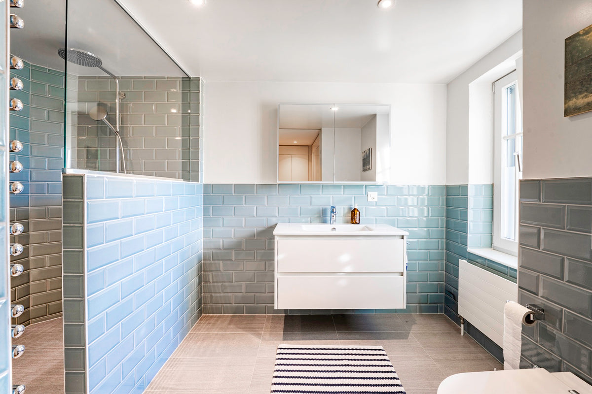 Salle de bain en carrelage métro gris-bleu à Genève